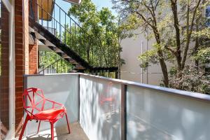 a red chair sitting on the balcony of a house at Davis Avenue Apartments in Melbourne