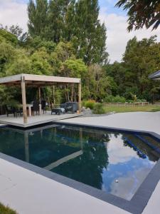 a swimming pool with a gazebo and a patio at Robyn's Retreat in Hamilton