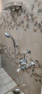 a shower in a bathroom with a faucet at Srinekatan Heritage Villa Homestay in Ahmedabad
