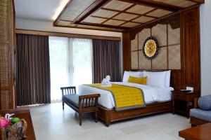 a bedroom with a bed and a chair in a room at Kenran Resort Ubud By Soscomma in Ubud