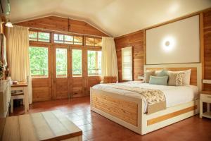 een slaapkamer met een bed, een bureau en ramen bij Misty Mountain Experience in Pīrmed