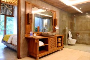 a bathroom with a sink and a mirror at Kenran Resort Ubud By Soscomma in Ubud