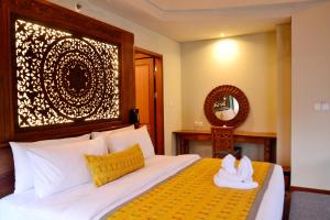 a bedroom with a bed with a cat sitting on a pillow at Kenran Resort Ubud By Soscomma in Ubud