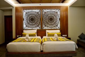 two beds in a bedroom with a window at Kenran Resort Ubud By Soscomma in Ubud