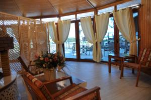 a living room with curtains and a table with flowers at Arcadia Hotel in Cıralı