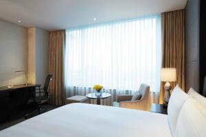 a hotel room with a bed and a desk and a window at LOTTE City Hotel Gimpo Airport in Seoul