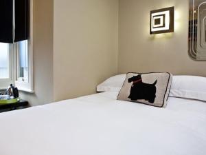 a bedroom with two beds with a cat pillow on the bed at Guest And The City in Brighton & Hove