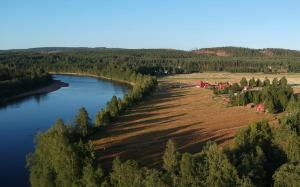 eine Luftansicht auf einen Fluss und einen Bauernhof in der Unterkunft Ekesberget Stugby Stuga 8 in Ekshärad