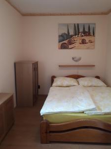 a bedroom with a bed and a painting on the wall at Ferienhaus Magyar in Lovas +20 photos