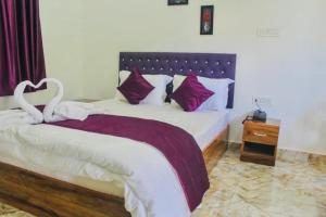 a bedroom with a bed with two swans on it at Zcube Andaman in Port Blair