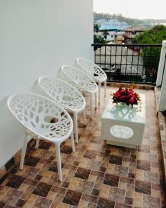 Zcube Andaman في ميناء بلير: مجموعة من الكراسي البيضاء وطاولة على الشرفة