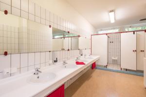 a bathroom with three sinks and two mirrors at Atelier & Herberge ViDo in Burg-Reuland