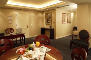 a hotel room with a table and chairs and a desk at Theoxenia House Hotel in Athens