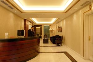 a man standing at a bar in a hotel lobby at Theoxenia House Hotel in Athens