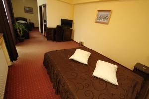 a hotel room with a bed with two pillows on it at Pensiunea Vranis in Sadova