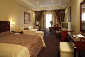 um quarto de hotel com duas camas e uma televisão em Theoxenia House Hotel em Atenas