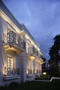 un edificio blanco con balcones y luces. en Theoxenia House Hotel en Atenas