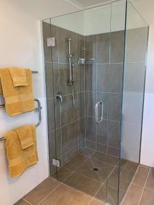 a bathroom with a shower with a glass door at Views to unwind - self contained unit w/king bed in Ruakaka