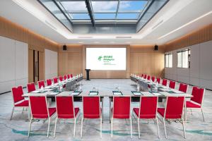 a conference room with a long table and red chairs at Holiday Inn Shanghai Nanjing Road by IHG in Shanghai