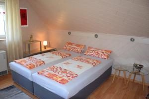 a bedroom with two beds with orange and white pillows at Gästehaus Bachra in Bachra