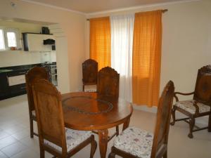 una sala da pranzo con tavolo e sedie in legno di Snow Leopard Lodge a Srinagar