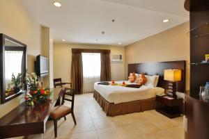 Una habitación de hotel con una cama con dos gatos. en Alpa City Suites Hotel, en Cebú