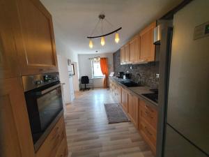 a kitchen with wooden cabinets and a wooden floor at En campagne, confortable in Le Pouzin