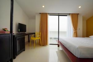 a bedroom with a bed and a desk with a television at Maison Khoi Homestay in Hoi An