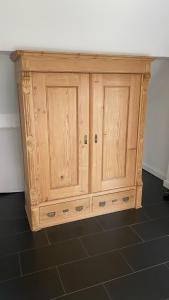 a wooden cabinet in the corner of a room at Lichtpüntje in Norden