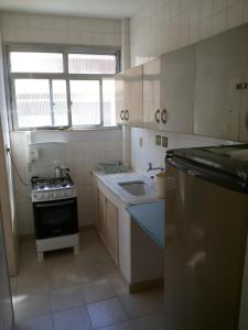 Apartamento Cabo Frio في كابو فريو: مطبخ صغير مع موقد ومغسلة