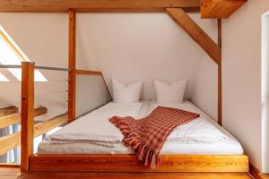 a bedroom with a bed in a room with stairs at Modernes Landhaus mit Sauna in Hohen Pritz