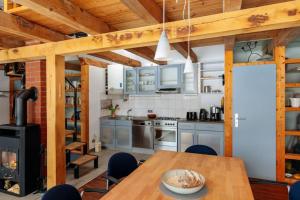 a kitchen with a table and a wood stove at Modernes Landhaus mit Sauna in Hohen Pritz