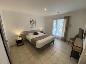 een slaapkamer met een bed en een groot raam bij Logis Hôtel L'Oliveraie in Cognac