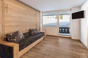 a living room with a couch and a large window at Haus Kreidl - Top 9 in Königsleiten