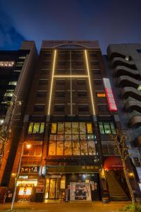 a tall building with lights in front of it at Sapporo Classe Hotel in Sapporo