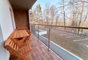 a porch with a wooden bench on a balcony at LAGUNA Apartament Polanica Residence 11 in Polanica-Zdrój