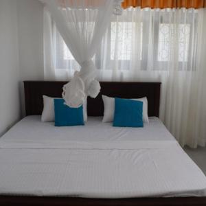 um quarto com uma cama grande e almofadas azuis e brancas em Villa 307 3 room apartment em Matara