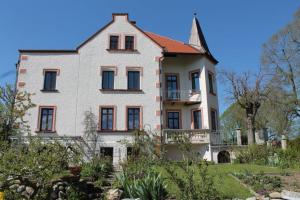 una gran casa blanca con un árbol delante en Ferienvilla-Teisendorf OG, en Teisendorf