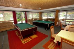 a room with a pool table and some tables at Rév Szálló Balaton in Szántód