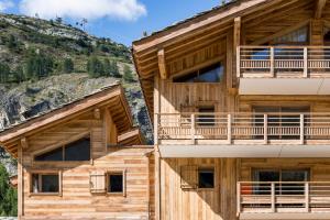 a log building with a mountain in the background at CGH Résidence Boutique Le Lodge des Neiges in Tignes