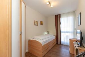 キュールングスボルンにあるBuesumer-Ring-Morgensonne-9395のベッドルーム(ベッド1台、テレビ付)