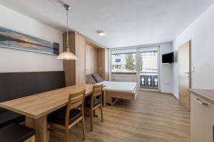 cocina y comedor con mesa de madera y sillas en Haus Kreidl - Top 31 en Königsleiten