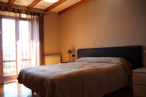 a bedroom with a bed and a large window at Hospedaje Nuestra Señora de Ujue in Tafalla