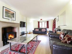 uma sala de estar com um sofá e uma lareira em Elder howe em Penrith