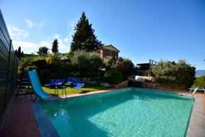 a swimming pool with chairs and a slide at La Valle di Anna in Lastra a Signa
