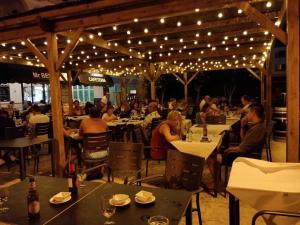 een groep mensen die aan tafel zitten in een restaurant met verlichting bij Apartamento Saura in Cala en Blanes