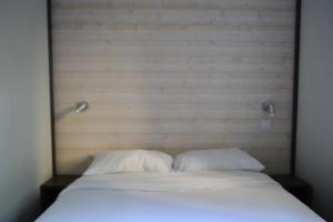 a bed with two white pillows in a room at Village Océanique in Le Bois-Plage-en-Ré +19 photos