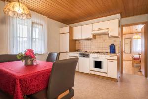 a kitchen with a table with a red table cloth at Zapfs Bauernhof Pfingstrose in Tettnang