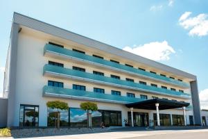 a large white building with blue balconies at Rebhan's Business und Wellness Hotel in Neukenroth