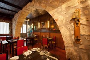 a restaurant with tables and chairs and a stone wall at Hotel Internacional Porto in Porto
